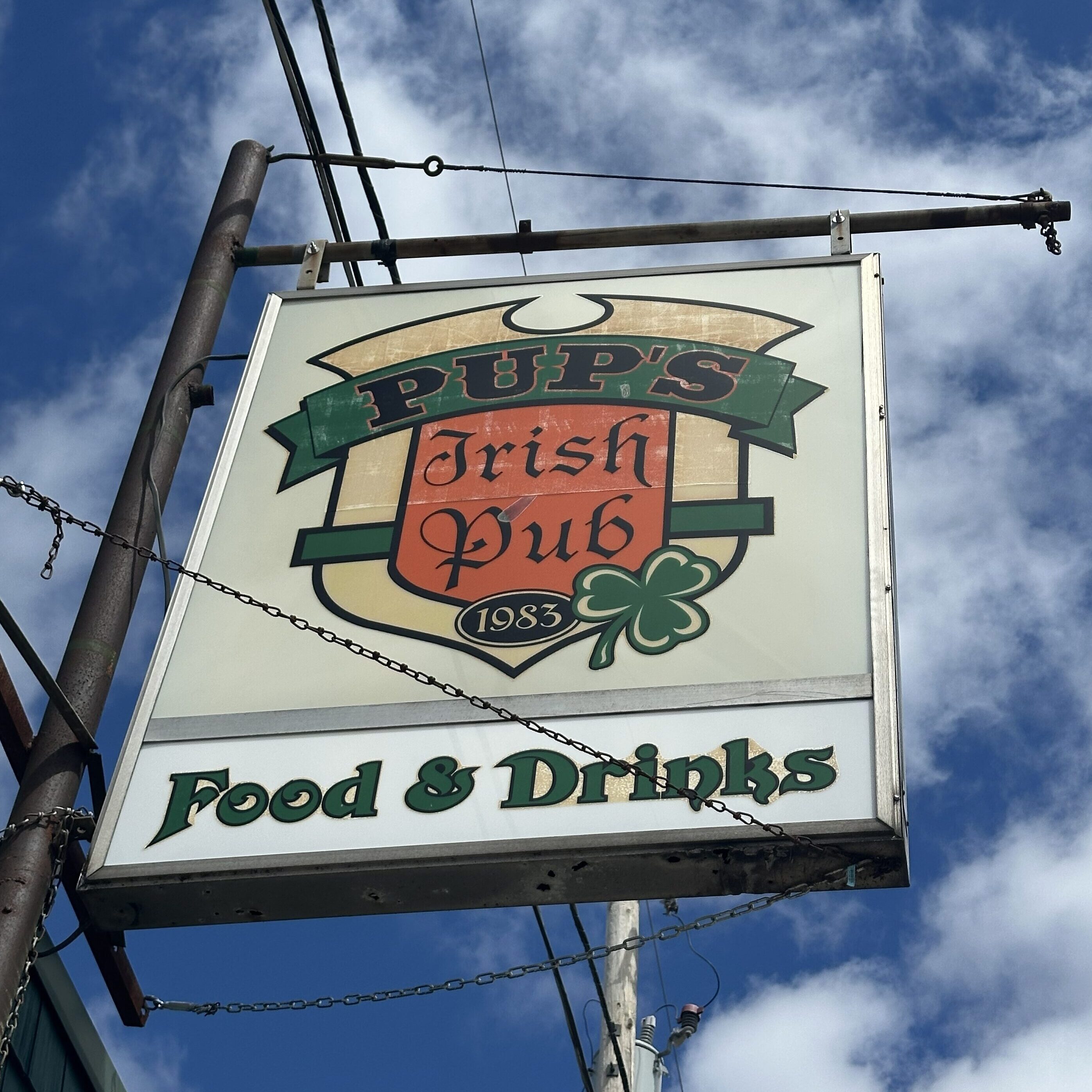 A large sign that says Pup's Irish Pub, Food and Drinks