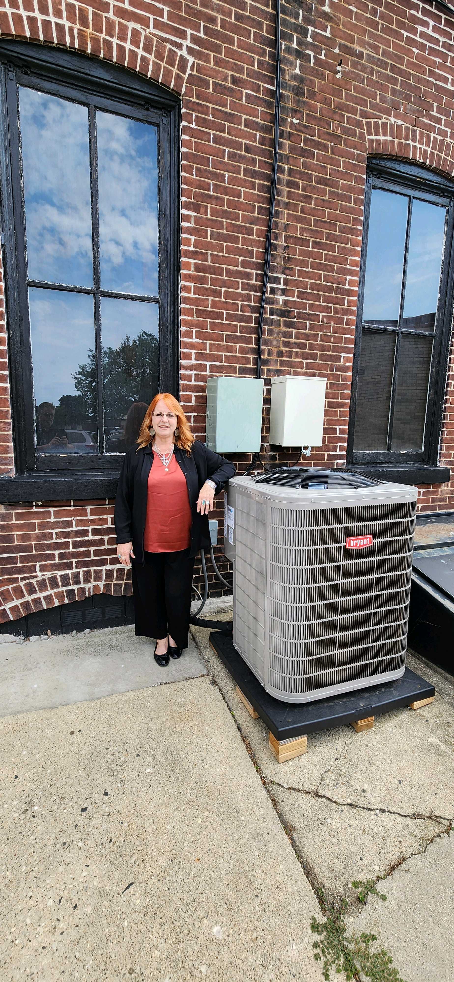 Pamela Zigler next to her new Air Conditioner unit