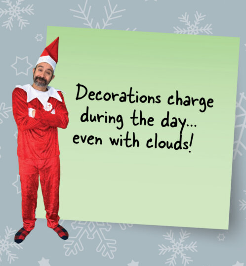 Man in a red elf costume stands with arms crossed next to a tilted light-green note that reads Decorations charge during the day even with clouds on a blue snowflake background.
