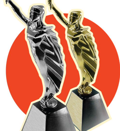 Two metallic trophy statues, one silver and one gold, stand on square bases with arms raised holding torches, set against an orange and pale background.