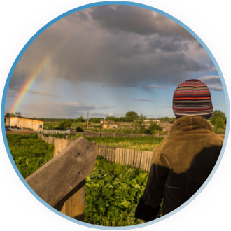 Child looking off into the distance at a rainbow