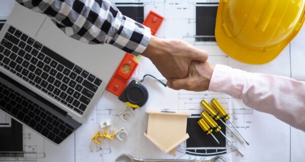 contractor handshake with blueprints